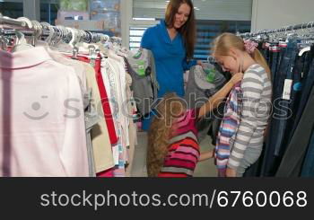 Mother with two daughters shopping for clothes in a clothing store