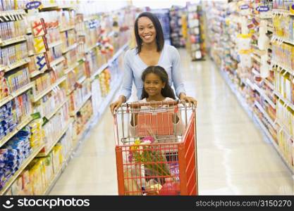 Mother with young daughter shopping at the grocery store.