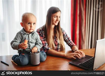 Mother works at home little kid helps her. Mom and son happy together at home, togetherness. Mother works at home little kid helps her