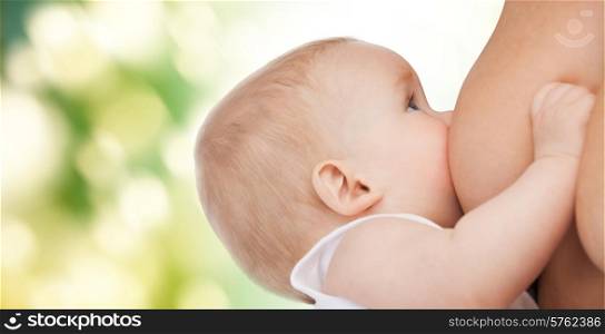 motherhood, children, people and care concept - close up of mother breast feeding adorable baby over green background