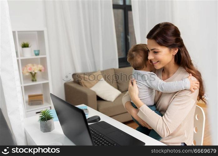 motherhood, multi-tasking, family and people concept - happy mother with baby and laptop working at home. happy mother with baby and laptop working at home. happy mother with baby and laptop working at home