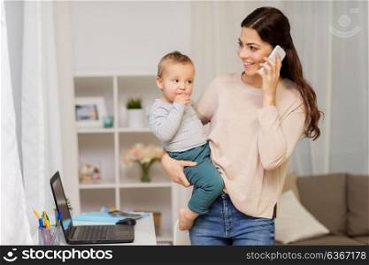 motherhood, multi-tasking, family and people concept - happy mother with baby calling on smartphone at home. mother with baby calling on smartphone at home
