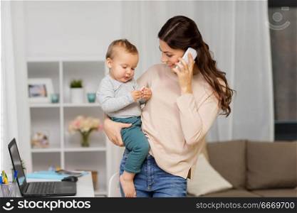 motherhood, multi-tasking, family and technology concept - happy mother with baby calling on smartphone at home. mother with baby calling on smartphone at home. mother with baby calling on smartphone at home