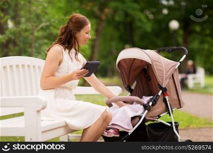 motherhood, technology and people concept - happy mother with tablet pc computer and baby girl stroller at summer park. happy mother with tablet pc and stroller at park