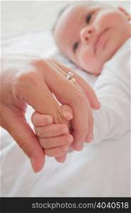 Mothers hand holding baby boys hand