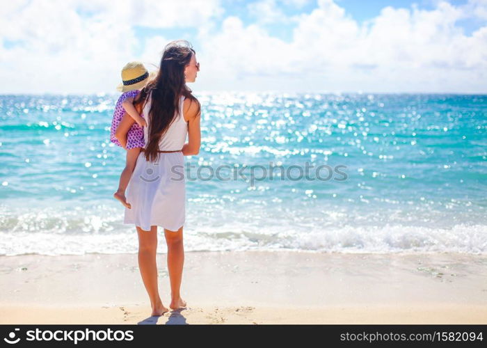 Mothher and her kid on the beach. Beautiful mother and daughter on the beach enjoying summer vacation.