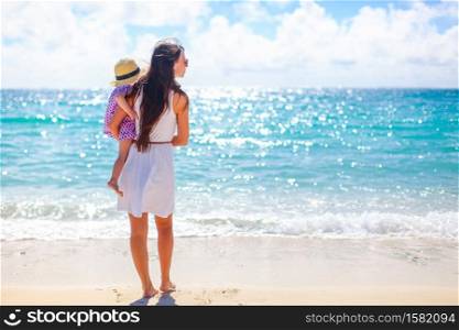 Mothher and her kid on the beach. Beautiful mother and daughter on the beach enjoying summer vacation.