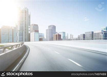 Motion blur flyover asphalt road with modern skyscraper building background.