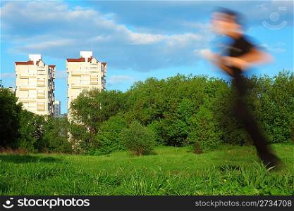 motion blur man running in park and two buildings