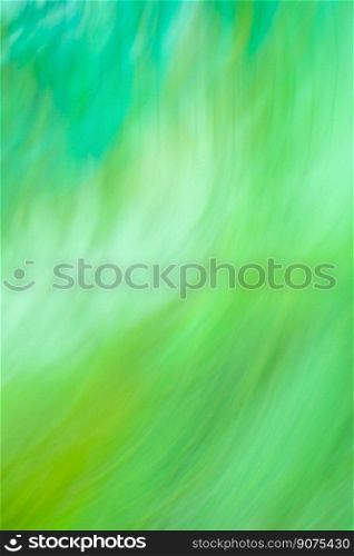 Motion blurred defocused abstract green background. Green abstract defocused motion blurred background.. Fresh summer wallpaper. Amazing green nature in motion.