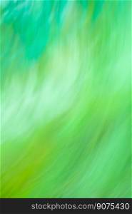 Motion blurred defocused abstract green background. Green abstract defocused motion blurred background.. Fresh summer wallpaper. Amazing green nature in motion.