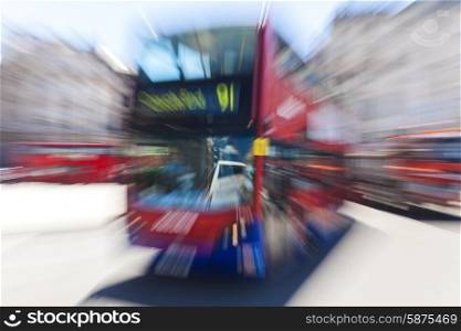 Motion blurred zoomed photograph of a red London double decker bus