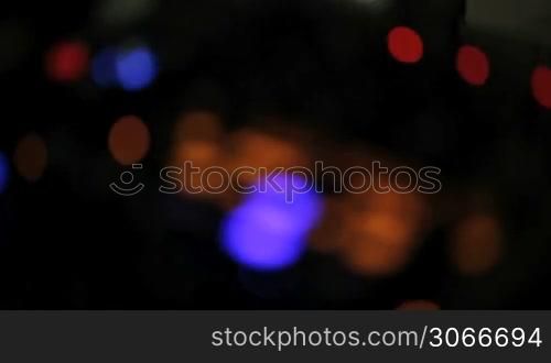 Motion clip moving in and out of focus on a disc jockeys colourful lights on a sound deck at night