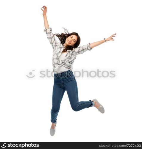 motion, freedom and people concept - happy young woman or teenage girl jumping over white background. happy young woman or teenage girl jumping
