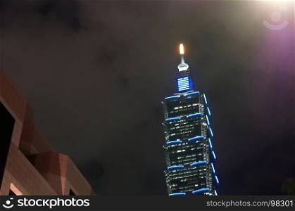 Motion of car driving by Taipei 101 at night.. Taipei, Taiwan - November 10, 2017 : Motion of car driving by Taipei 101 at night. Taipei 101 is the tallest building in the world.