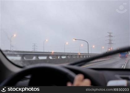 Motion of car driving on heavy raining day and focusing on car dashboard