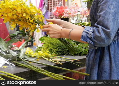 Motion of florist prepares a bouquet of flowers for customer, close up on hand.. Taipei, Taiwan - October 29, 2017 : Motion of florist prepares a bouquet of flowers for customer, close up on hand.
