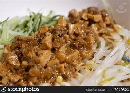 Motion of noodles with fried bean and meat sauce inside Chinese restaurant