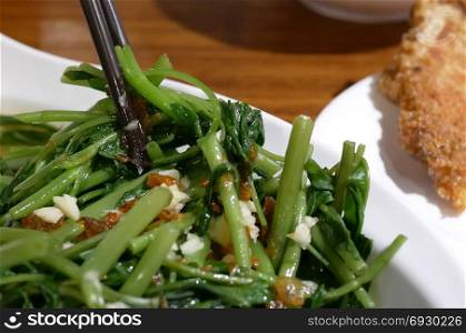 Motion of people eating vegetable inside Chinese restaurant