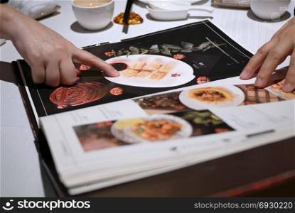 Motion of people looking at menu inside Chinese restaurant. Taipei, Taiwan - October 21, 2017 : Motion of people looking at menu inside Chinese restaurant