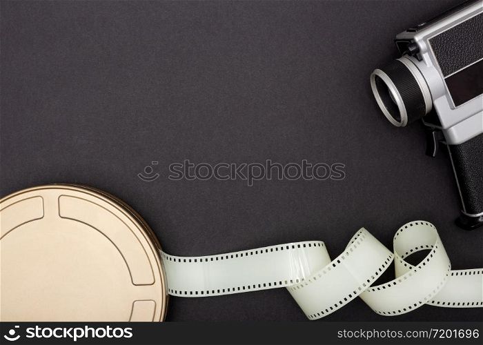 Motion Picture Film Can, film camera and film strip on black background. Movie or TV background. Top view Copy space