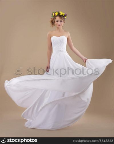 Motion. Woman with Wreath of Flowers and Fluttering Light Dress