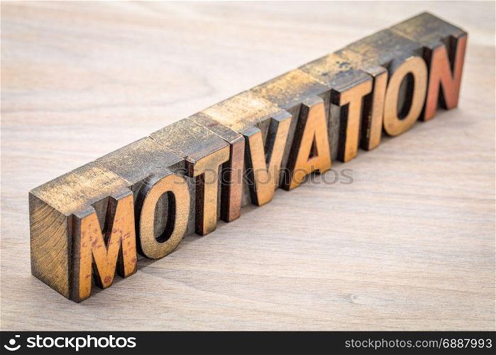 motivation word abstract in vintage letterpress wood type against grained wood