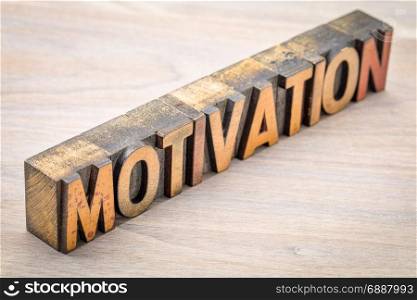 motivation word abstract in vintage letterpress wood type against grained wood