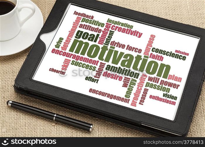 motivation word cloud on a digital tablet with a cup of coffee