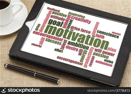 motivation word cloud on a digital tablet with a cup of coffee