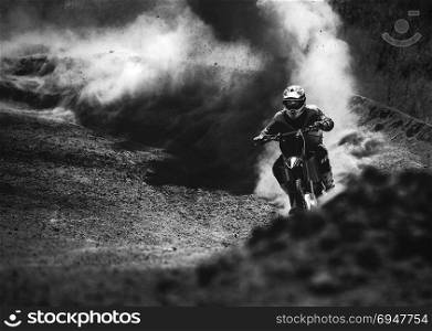 Motocross racer accelerating in dust track, Black and white photo. Motocross racer accelerating in dust track, Black and white, high contrast photo
