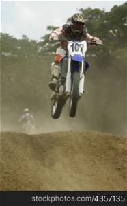 Motocross rider performing a jump on a motorcycle
