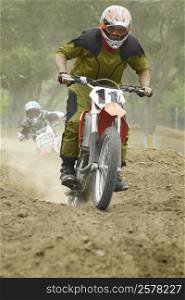 Motocross riders riding motorcycles