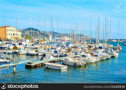 Motorbats and yachts moored in marina of coastal town, sunny day, Italy