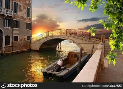 Motorboats and old bridge in Venice, Italy. Old bridge in Venice