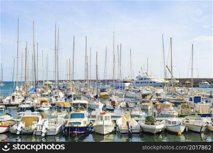 Motorboats and yachts moored in marina, bright sunshine day, Italy