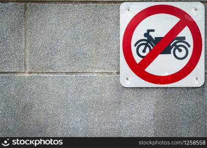 Motorcycle no entry sign install on concrete wall in front of tunnel under road. Traffic sign to prohibit motorcycle. Restrictive signs. Motorcycle caution and stop driving to this way. Ban motorbike
