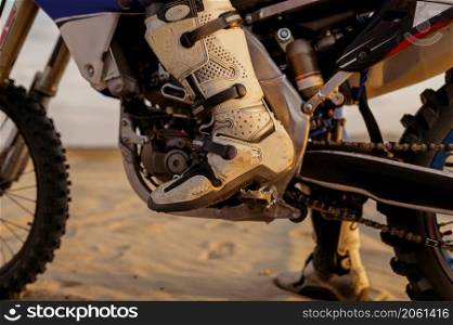 Motorcycle trials during motocross competition. Closeup rider boots. Motorcyclist team ready to start. Motorcycle trials during motocross competition closeup rider boots