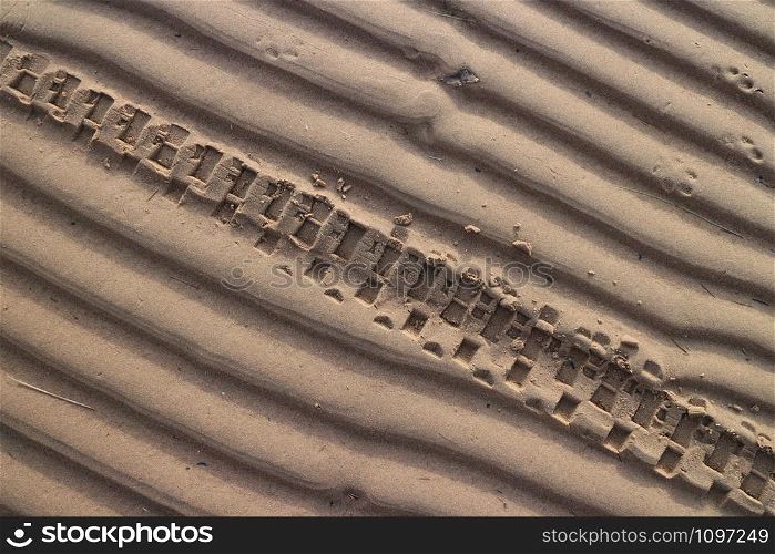 motorcycle wheel imprint on the sand of a beach