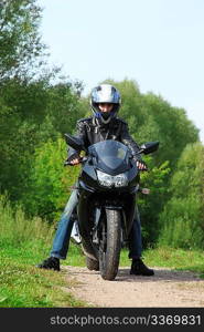motorcyclist standing on country road