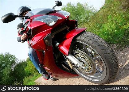 motorcyclist standing on country road, bottom view