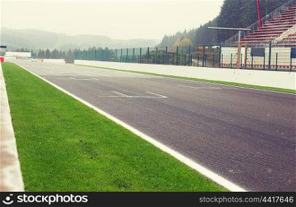 motosports, extreme and race concept - close up of speedway track or road and stands