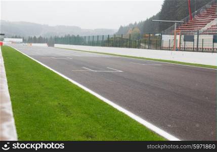 motosports, extreme and race concept - close up of speedway track or road and stands