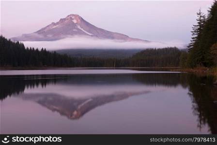 Mount Hood stands alone in the fall at sunrise ubove peaceful Trillium Lake