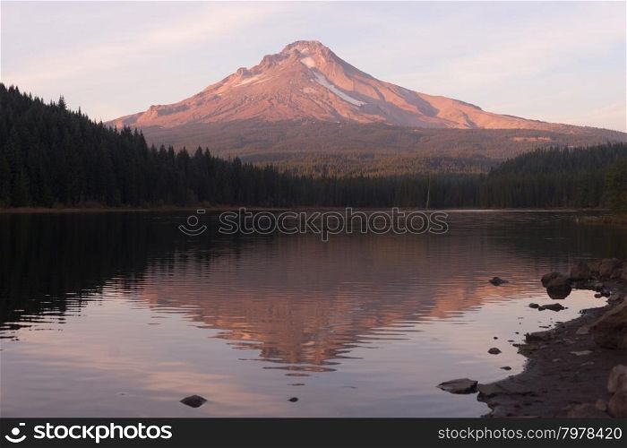 Mount Hood stands alone in the fall at sunrise ubove peaceful Trillium Lake