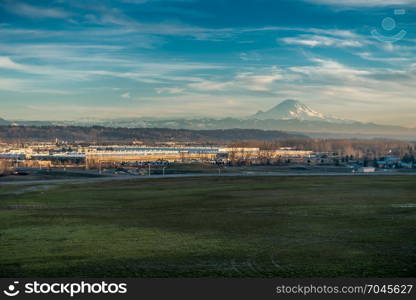 Mount Rainier rises above warehouses in Kent, Washington.