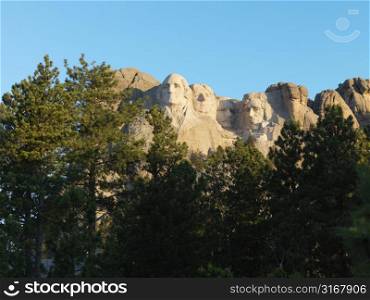 Mount Rushmore National Memorial seen through trees.