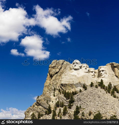 Mount Rushmore National Memorial with blue cloudy sky.