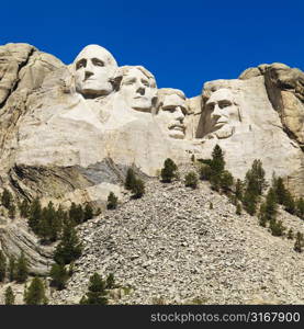 Mount Rushmore National Memorial with mountain and trees.