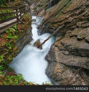 Mountain alpine autumn Wimbachklamm gorge and Wimbach stream with wooden path, Berchtesgaden national park, Alps, Bavaria, Germany. Picturesque traveling, seasonal and nature beauty concept scene.